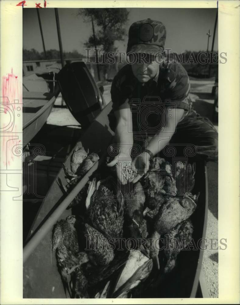 1990 USFWS agent Yene Moore displays bait used to attract ducks - Historic Images