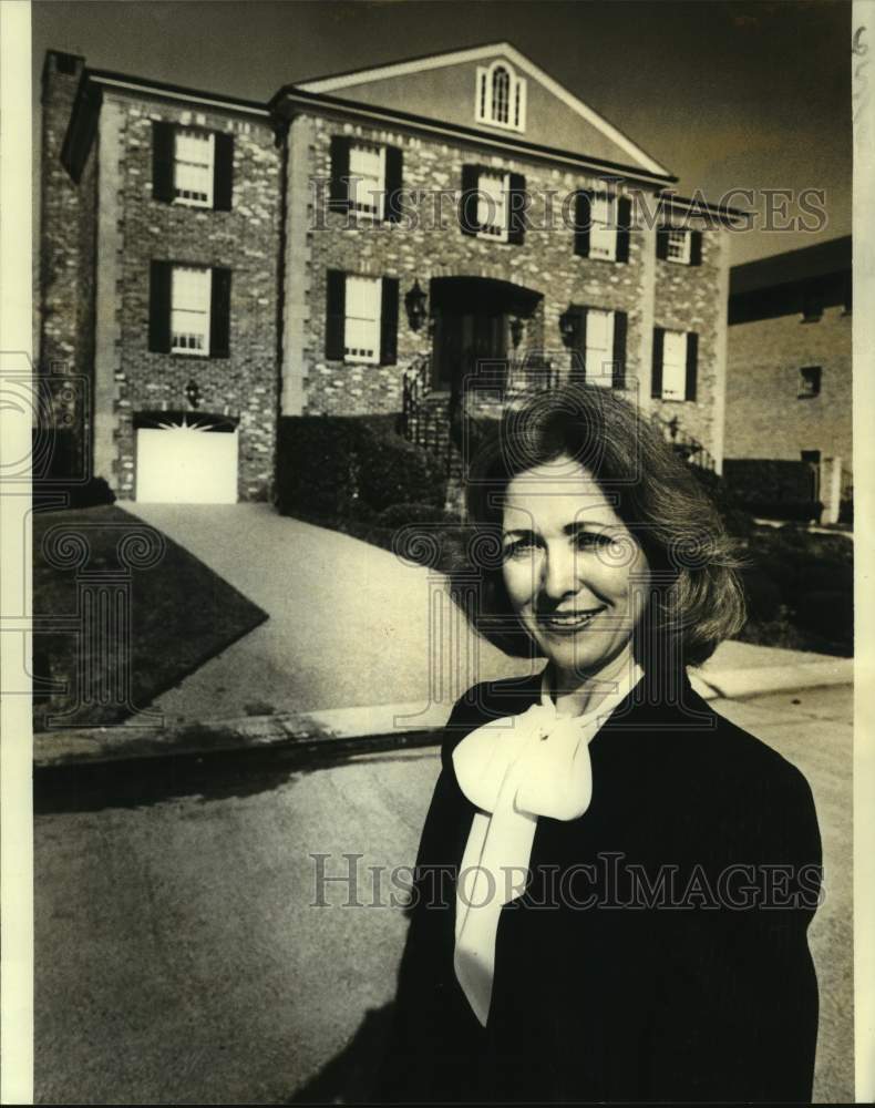 1982 Betty Holder stands before highest priced listing in Metairie. - Historic Images