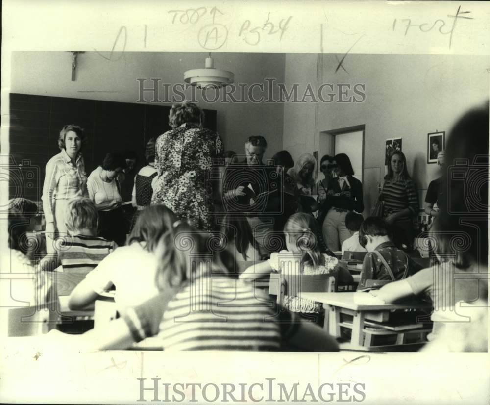 1978 Dr. Hughle Hughes examines 4th Grade English language text. - Historic Images