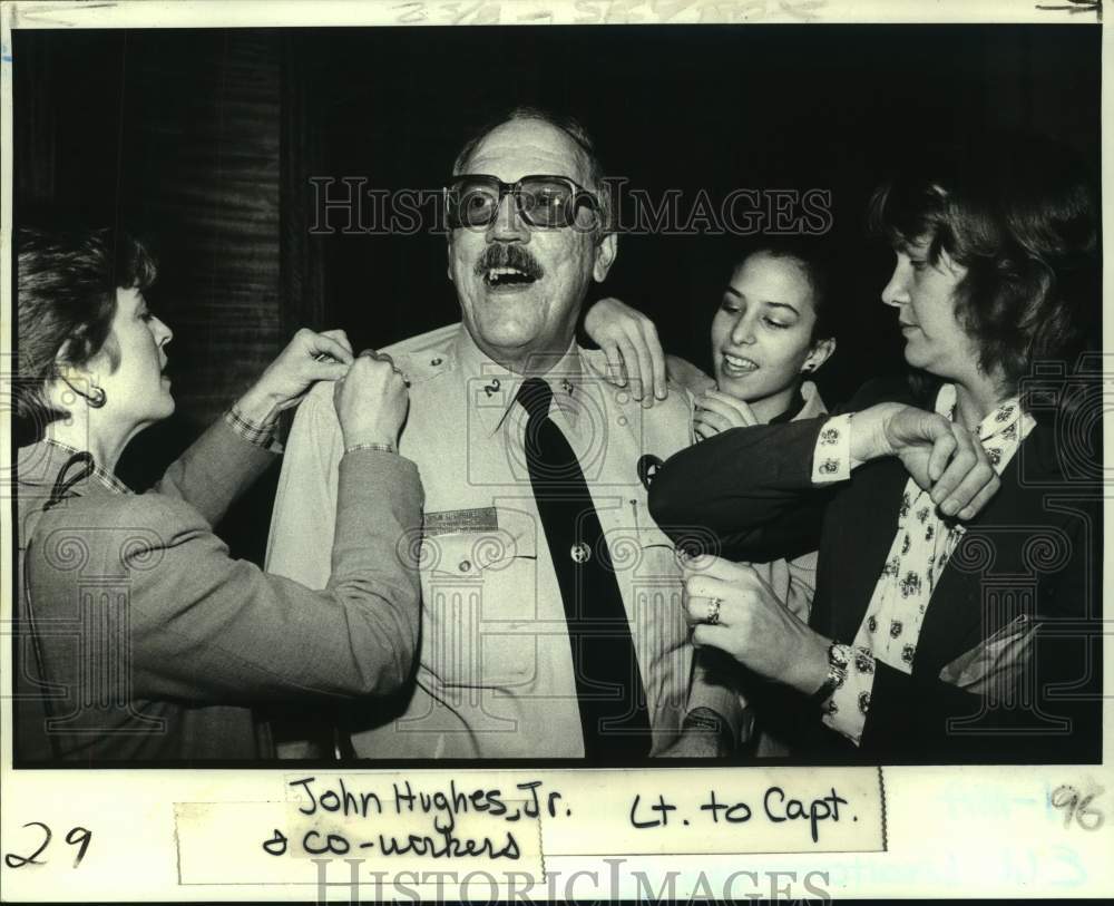 1982 Lieutenant John Hughes with co-workers pinning Captain bars on. - Historic Images