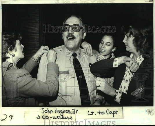 1982 Lieutenant John Hughes with co-workers pinning Captain bars on. - Historic Images