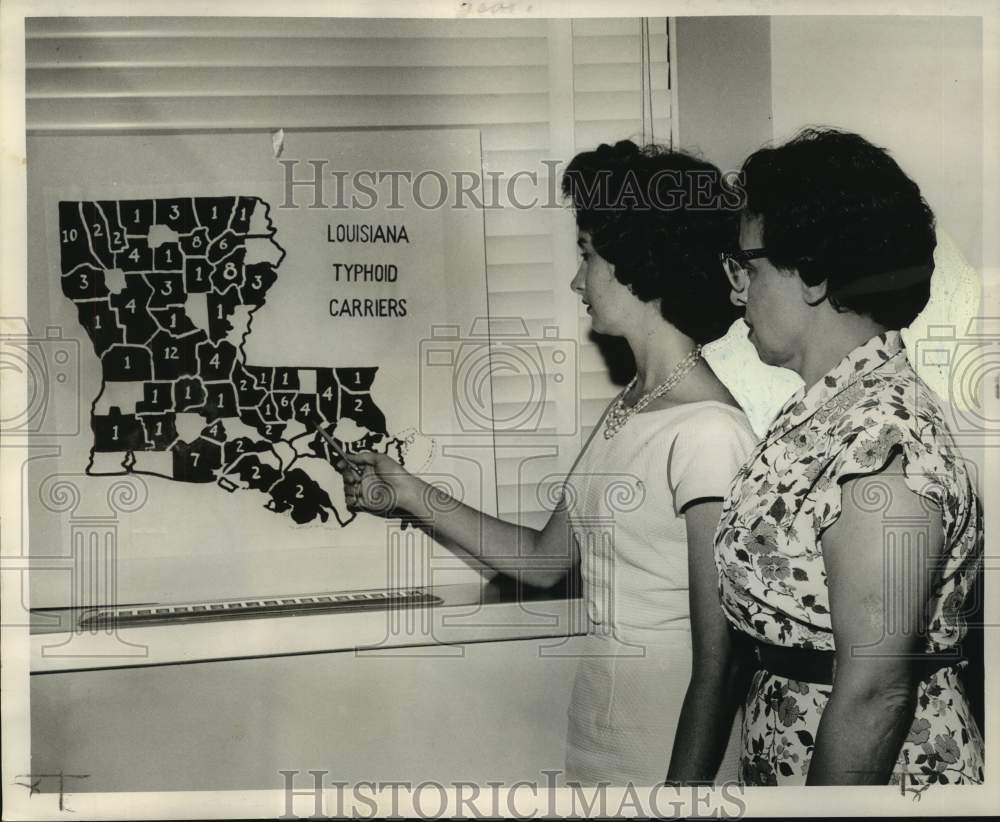 1961 Mrs. Jesse Hodges and Mrs. Richard Rudolph examine health map - Historic Images