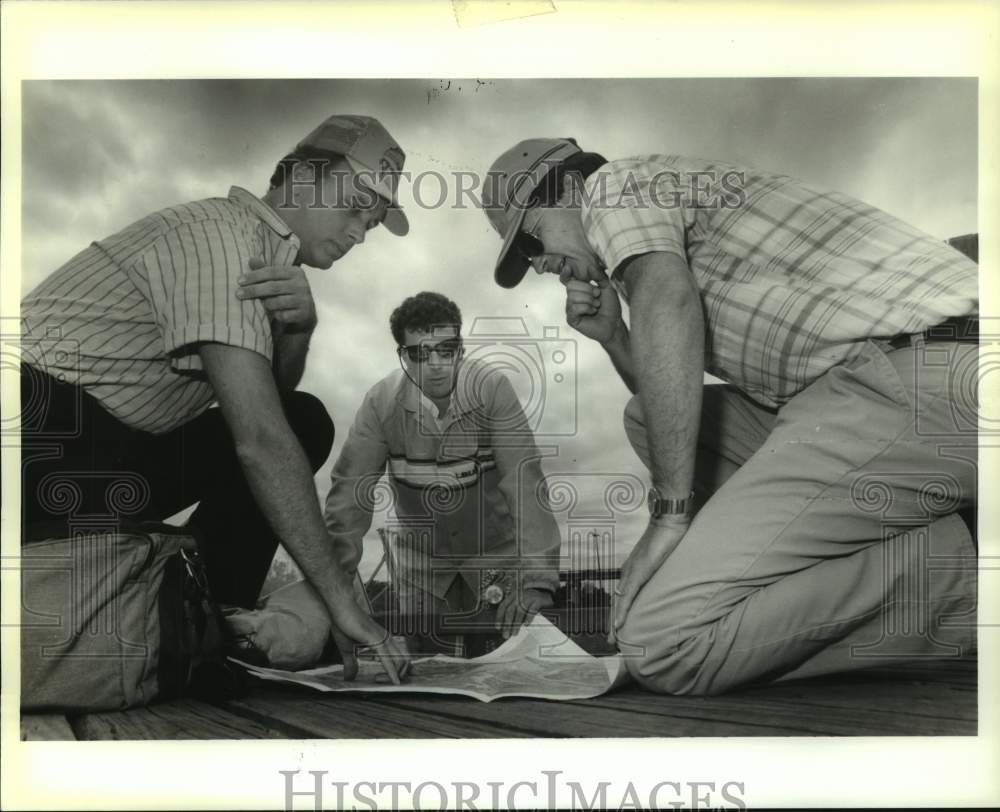 1990 Press Photo Samuel Holder, Deano Bonano and Michael Loden look at the chart - Historic Images