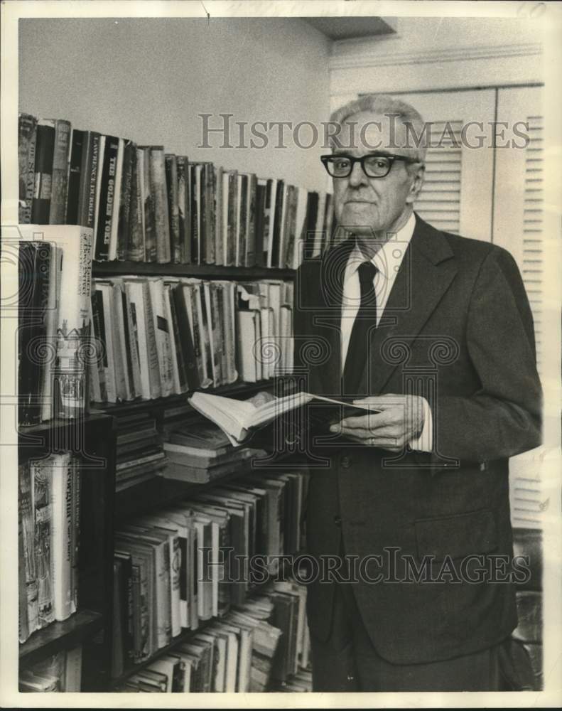 1976 Press Photo Bank official Edwin Jane selects a book from Manor&#39;s Library - Historic Images