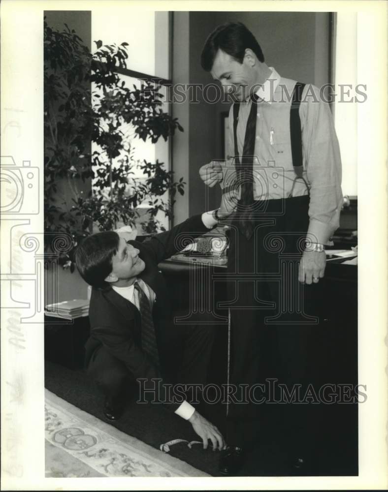 1989 Press Photo Jacques Roy of Tom James Co. measures pants of Michael Mestayer - Historic Images