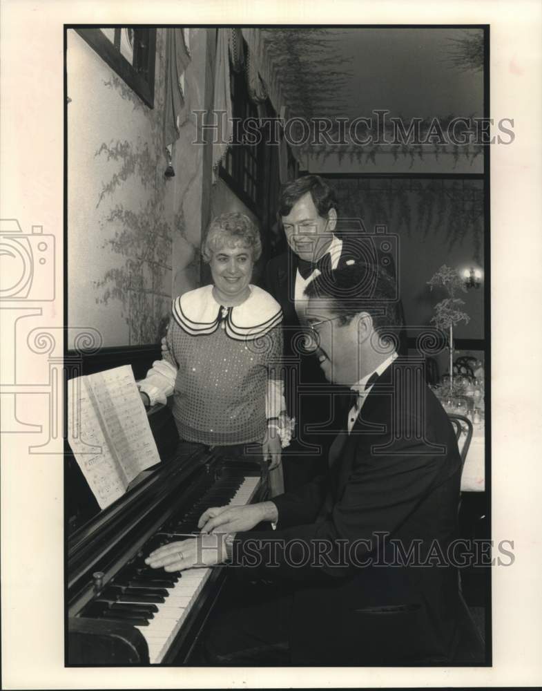 1991 Press Photo Social gala attendees gather around pianist - Historic Images