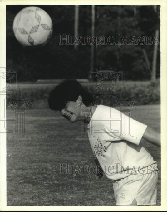 1989 Press Photo Joe Ingraham grimaces as he returns a soccer ball with his head - Historic Images