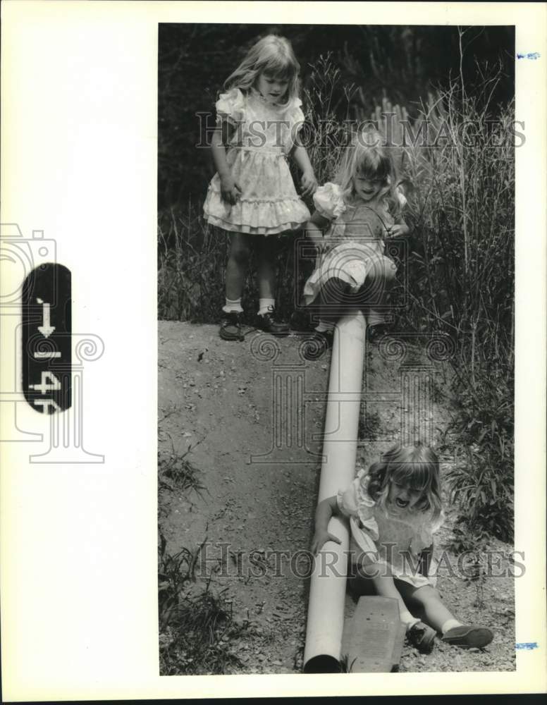 1989 Press Photo Triplets Kylee &amp; Kyleen watch Kenita slide down an incline - Historic Images