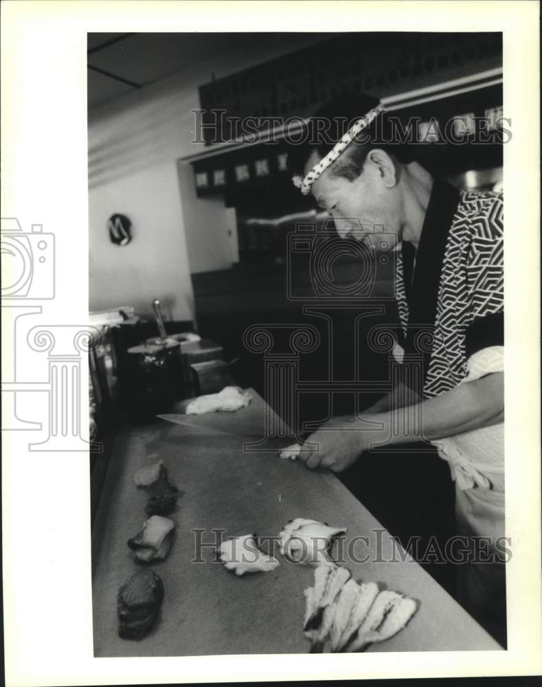 1989 Press Photo Ya Gu Chi- Sushi Chef at Ichiban cuts up some meat - Historic Images