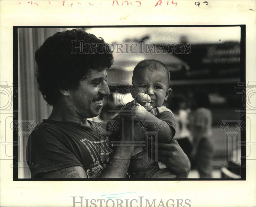 1976 Press Photo Joseph and his father get ice cream at the Arabi Bank giveaway. - Historic Images