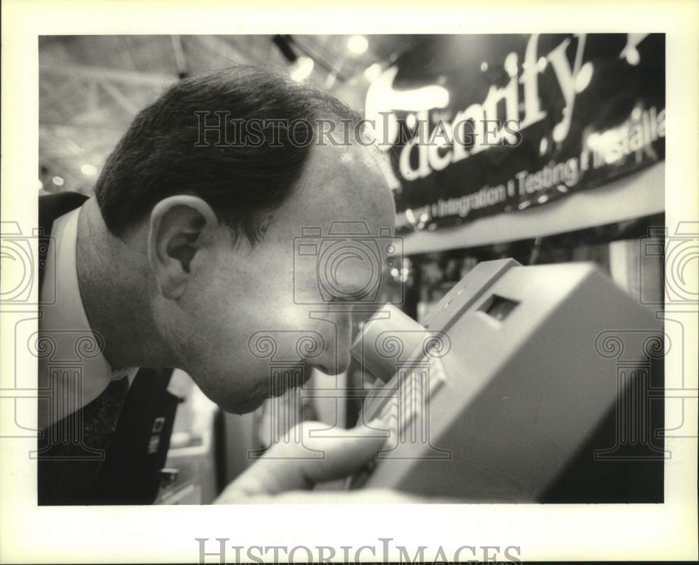1995 Press Photo Kim Bowers demonstrates retinal recognition system at the booth - Historic Images