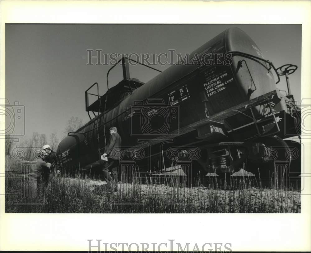 1989 Press Photo Illinois Central Railroad workers stand by one of derailed cars - Historic Images