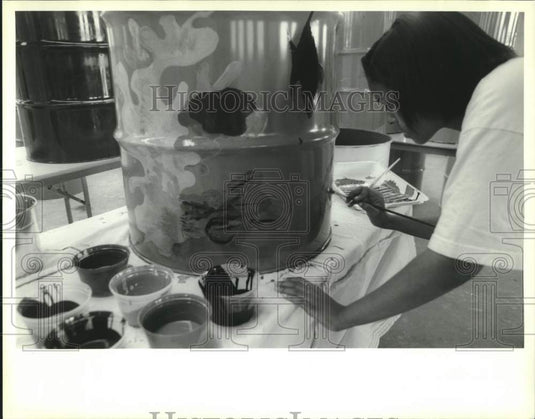 1993 Press Photo Eroniffa Ibrahim paints undersea scene on side of trash can. - Historic Images