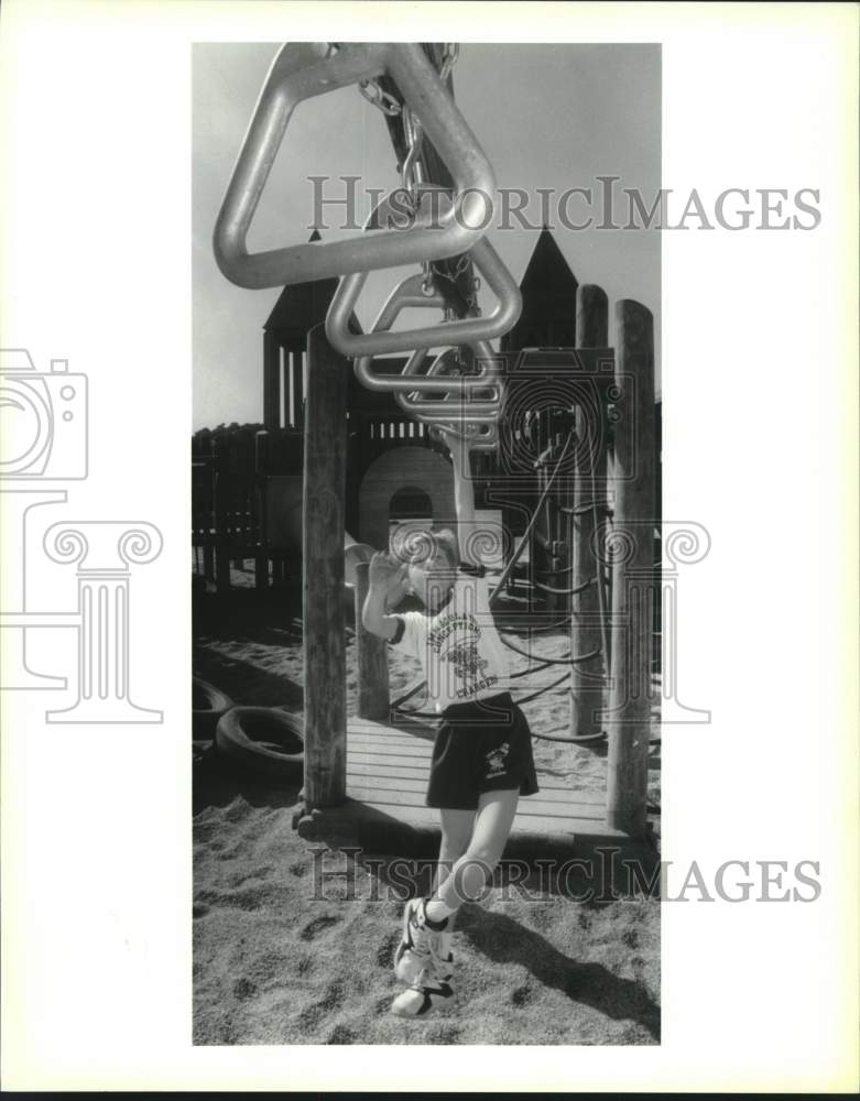 1993 Press Photo Jonathan Usey works his way hand over hand across playground. - Historic Images