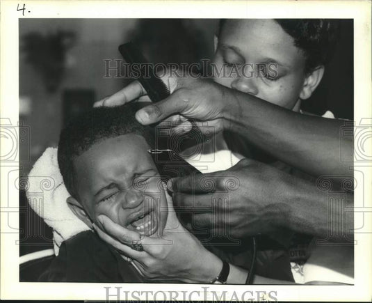 1989 Press Photo Donald Julien cries in barber's chair having his hair cut - Historic Images