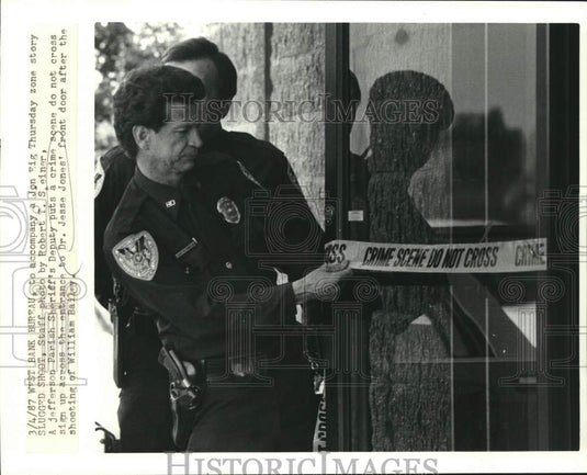 1987 Press Photo Officer places crime scene tape around Dr. Jesse Jones' home - Historic Images
