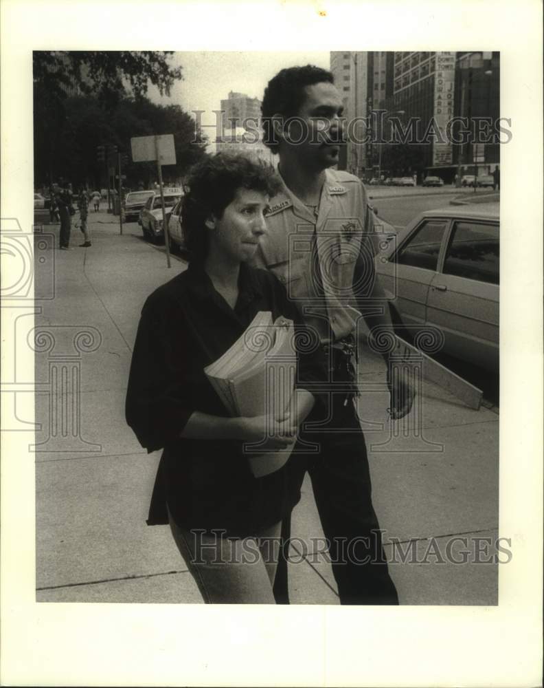 1987 Press Photo Ivonne Jurisich escorted by a Civil Court deputy to a car - Historic Images