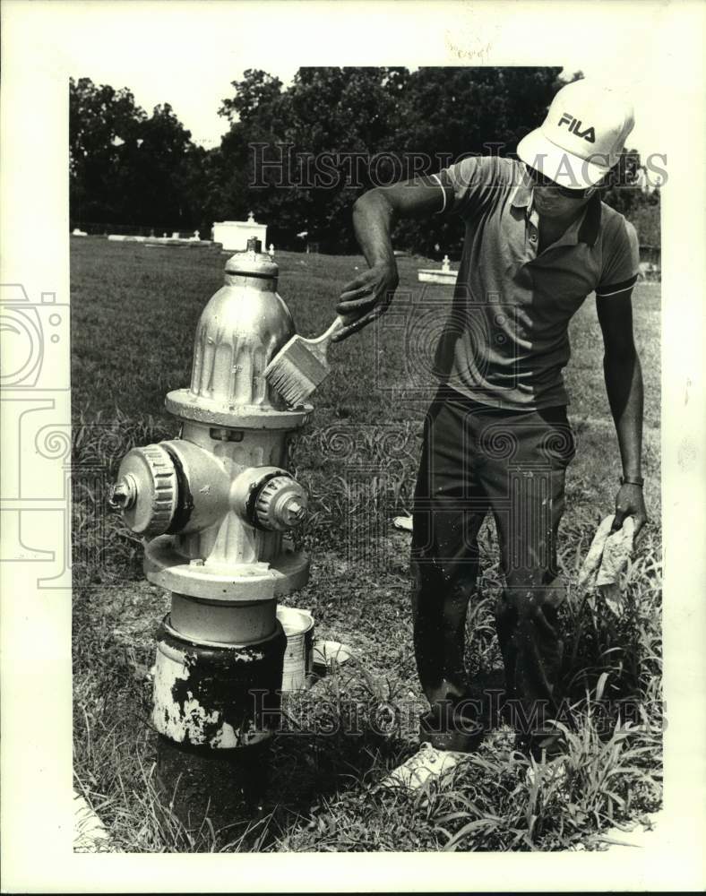 1986 Press Photo Keith Harris re-painting fire hydrants along 3rd st. in Kenner - Historic Images