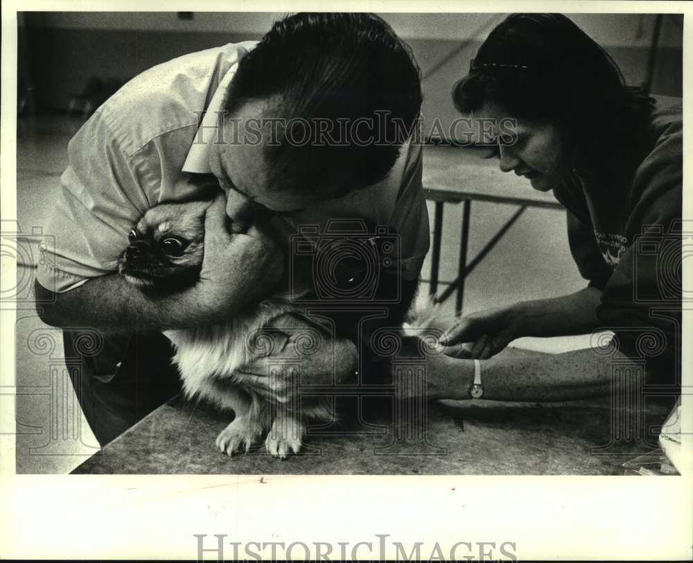 1987 Press Photo Noel Yambra holds Nikki at Greenlawn Gym as he gets rabies shot - Historic Images