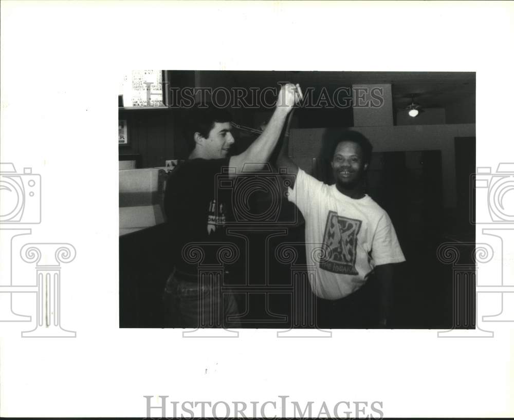 1992 Press Photo Murphy Hines hi-fives coworker, Gus Gelpi - Historic Images