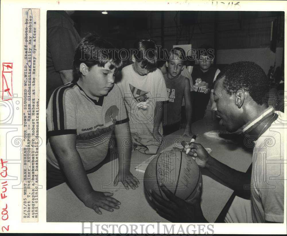 1985 Press Photo Billy Ray Hobley autographs basketball for Robert Herbert - Historic Images