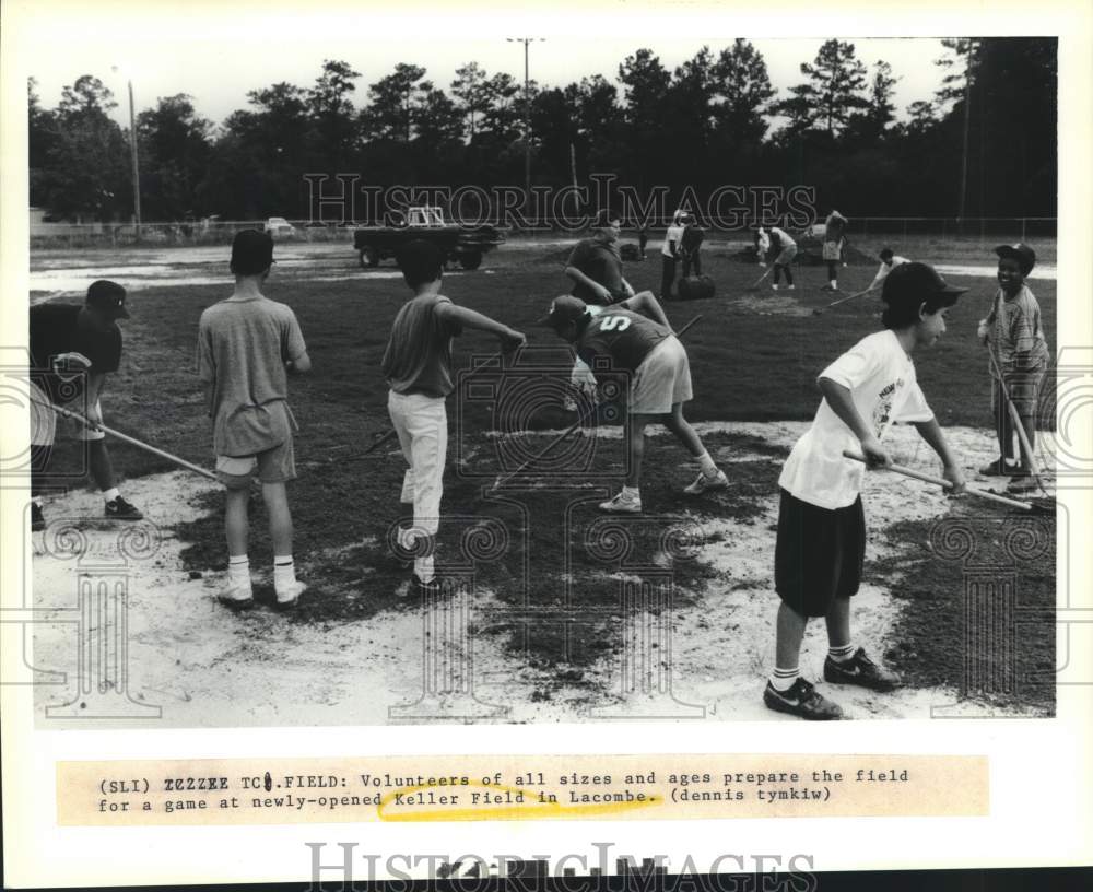 1991 Press Photo Volunteers prepare the hockey field at Keller Field in Lacombe - Historic Images