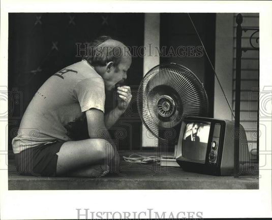 1987 Press Photo A.J. Keiser outside house in Calhoun with fan and tv, too hot! - Historic Images