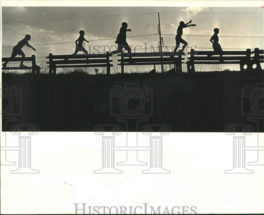 1987 Press Photo A group of youngsters playing along Jefferson Highway levee - Historic Images