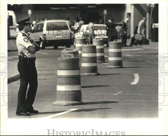 1989 Press Photo Kenner Policeman directing traffic at airport in Kenner - Historic Images
