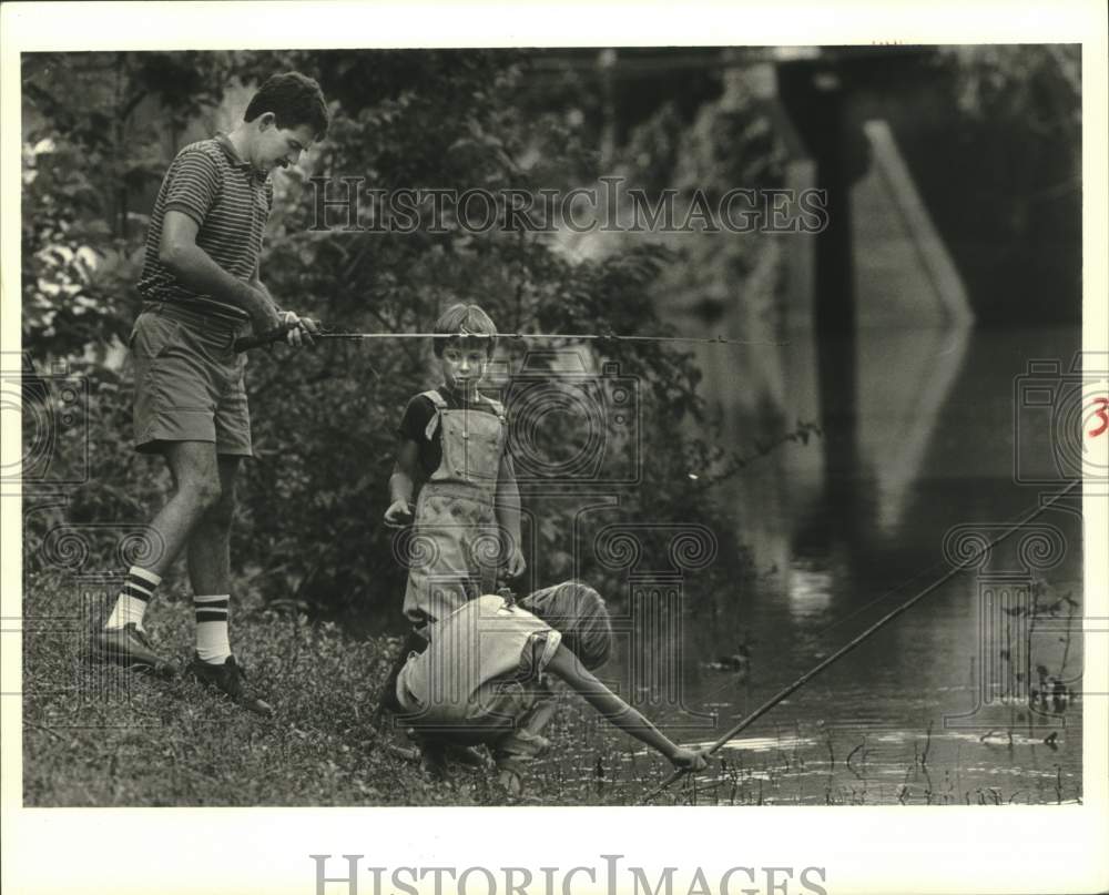 1986 Press Photo Michael Huber fishing with his sons on river banks - Historic Images