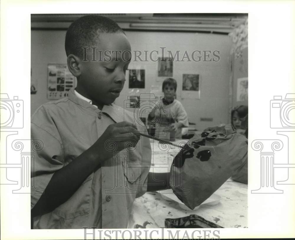 1995 Press Photo Johnny Lee paints mouth and teeth on his paper bag pumpkin - Historic Images