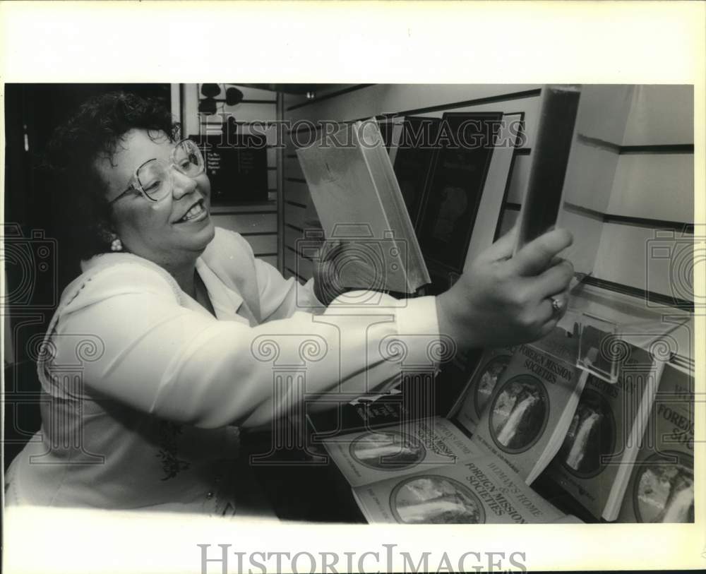 1990 Press Photo Gayle Music and Book Store owner Carolyn LeBrana stocks shelves - Historic Images