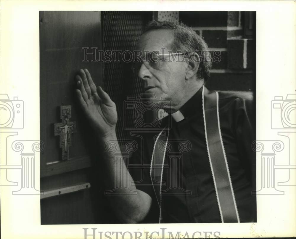 1989 Press Photo Monsignor Earl LaRose in the confessional box in his church - Historic Images