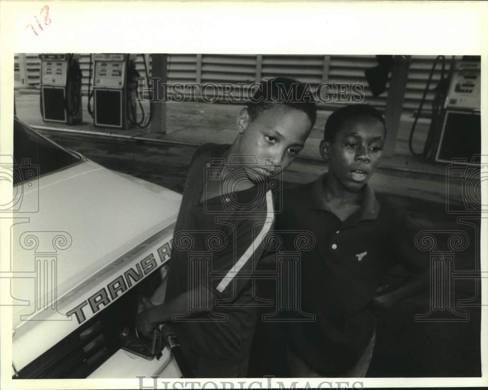 1988 Press Photo Jomar Jackson pumps gas while watching the dollar value. - Historic Images