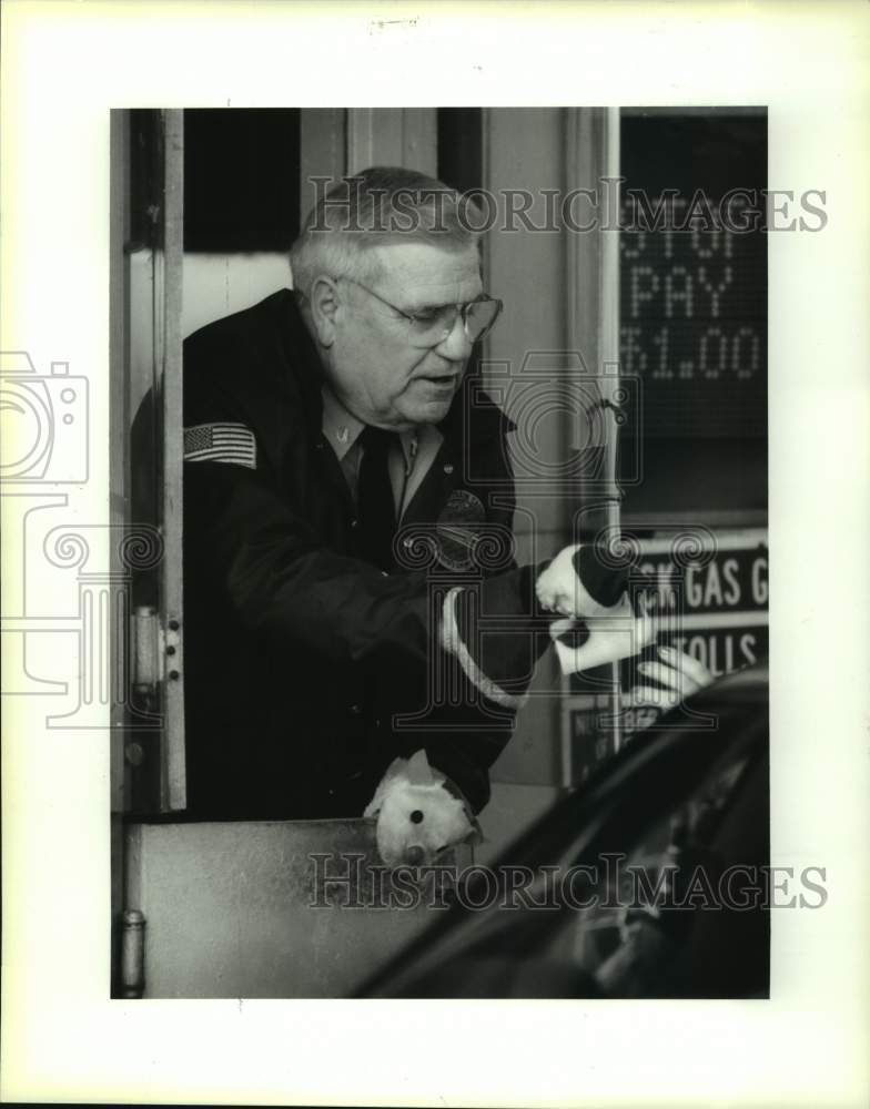 1993 Press Photo Causeway Bridge tolltaker Hap Otillio wearing hand puppets - Historic Images