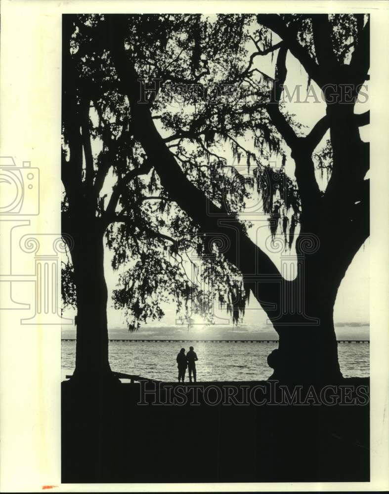 1987 Press Photo A couple enjoys sunset along the banks of Lake Pontchartrain - Historic Images