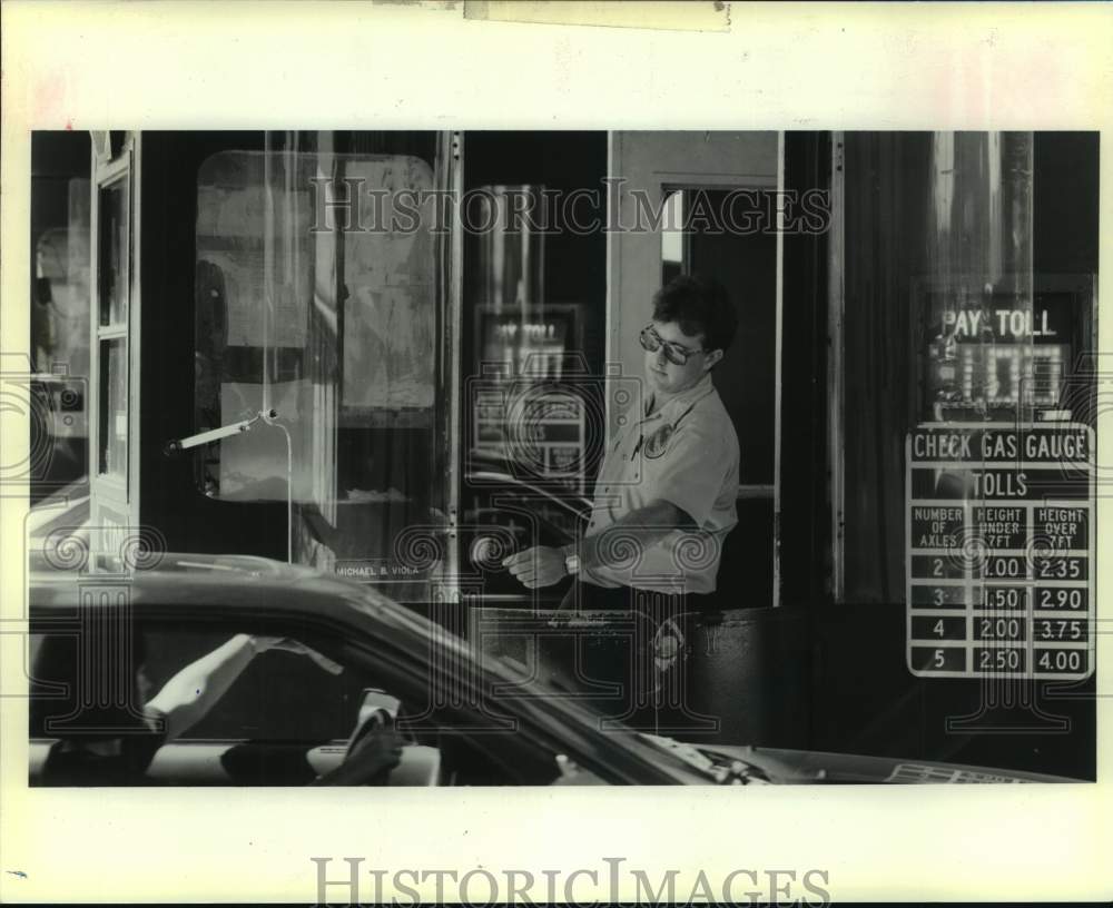 1989 Press Photo Motorist on the toll booth at Lake Pontchartrain Causeway - Historic Images