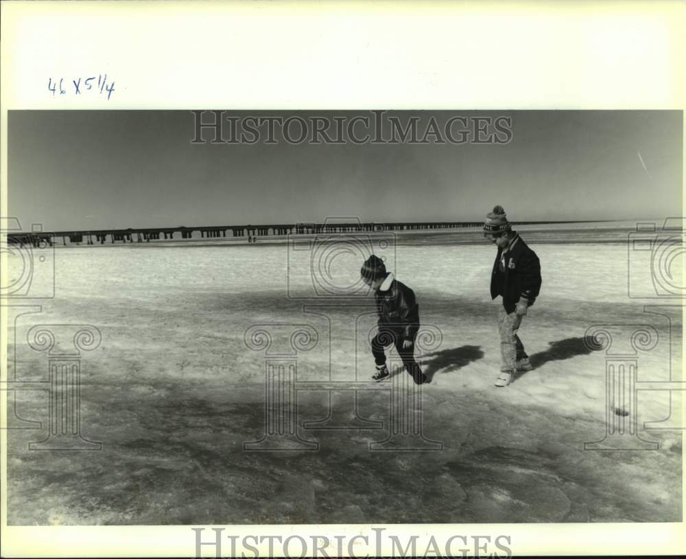 1990 Press Photo Two children playing on the frozen Lake Pontchartrain Waters - Historic Images