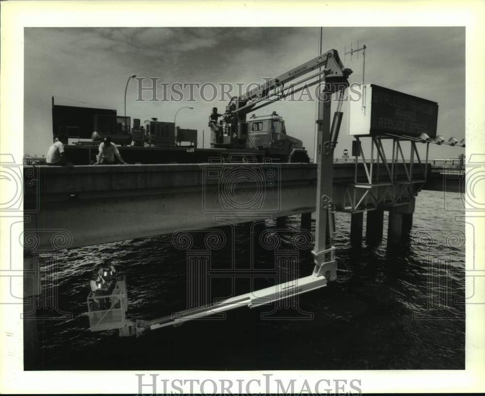 1994 Press Photo Causeway workers operate the Reach-All basket under the bridge - Historic Images