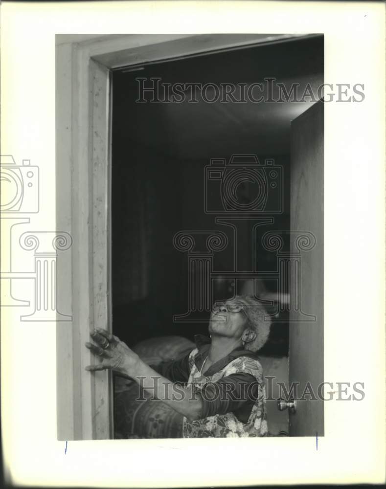 1990 Press Photo Gladys Jackson checking the weather stripping on her front door - Historic Images