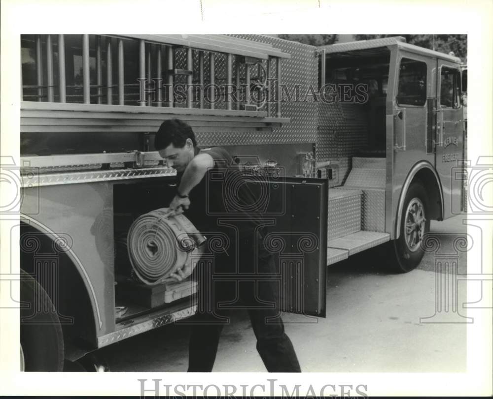 1990 Press Photo Kenner fireman Ronnie Scharwath, checking the spare hose - Historic Images