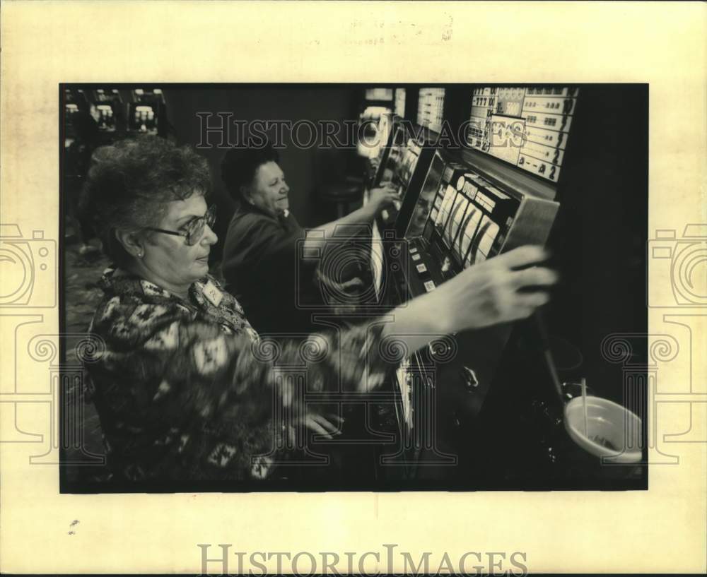 1994 Press Photo Audrey Gros pulls handle of slot machine with Annie Champagne - Historic Images