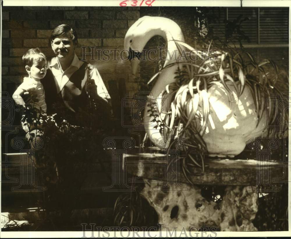 1987 Press Photo Metairie-Joey Lirett &amp; 2-year-old Eric Fernandez water plants - Historic Images