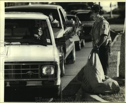 1990 Press Photo A motorist hands off her tax forms to Kenneth Leblanc - Historic Images