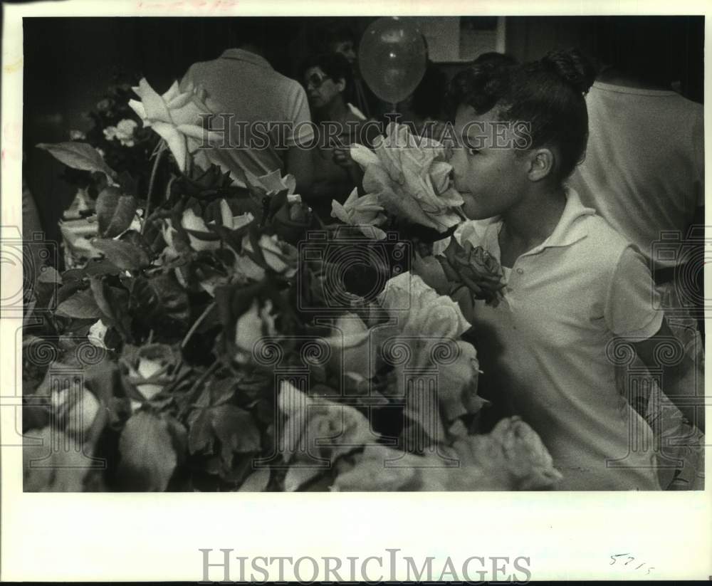 1986 Press Photo Tamia Randolph smells a rose at New Orleans Rose Society booth - Historic Images