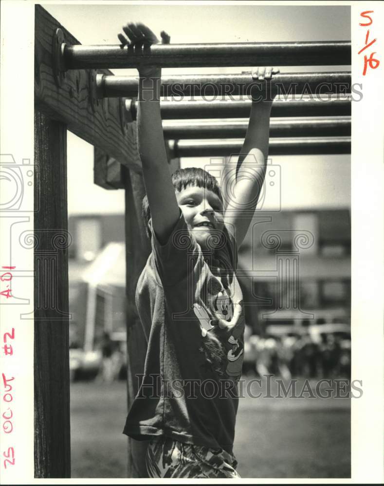 1987 Press Photo Swinging on the Monkey Bars, end of school in New Orleans. - Historic Images