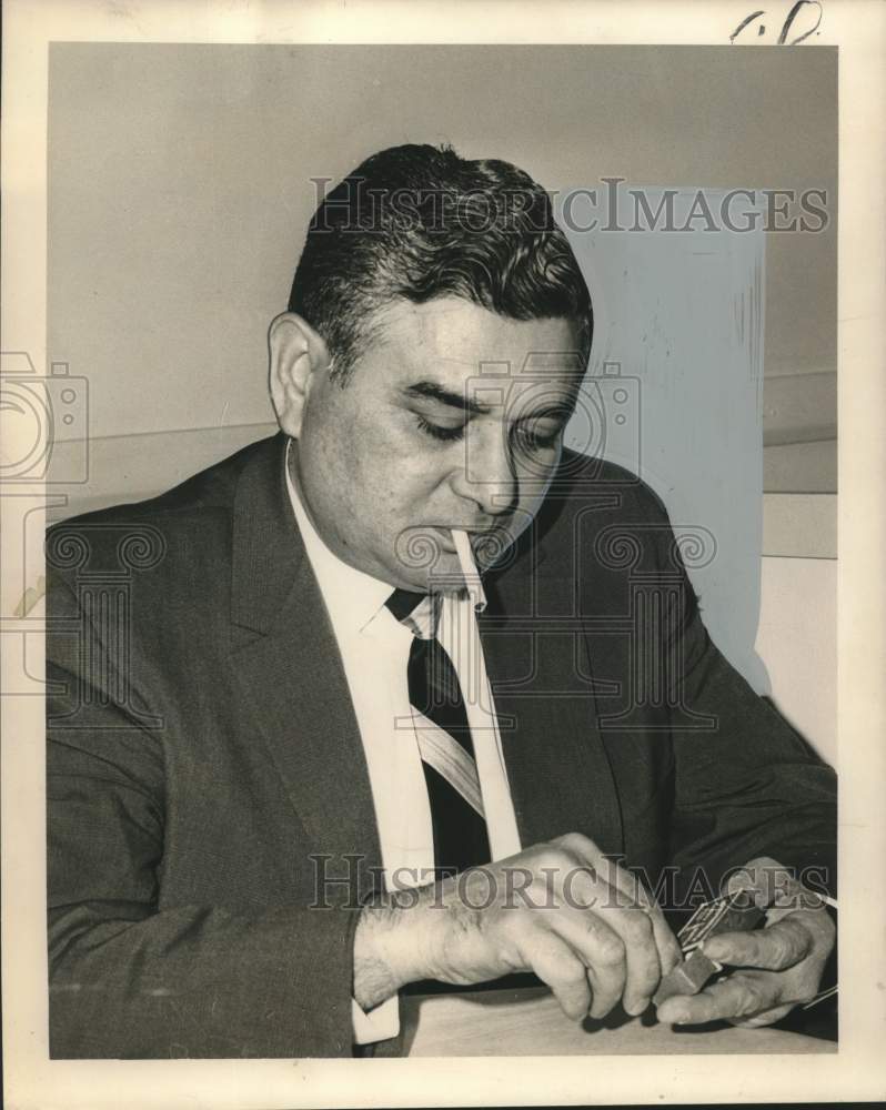 1965 Press Photo Henry L. Liuzza, Racing Commissioner having a cigarette-Historic Images