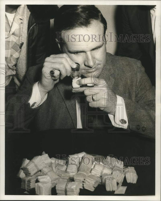 1969 Byron Legendre of DA's Office inspecting the contraband - Historic Images