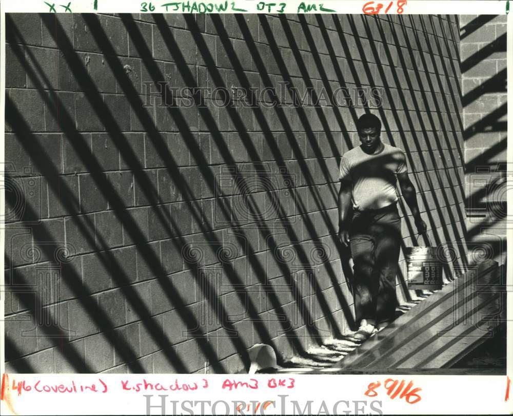 1987 Press Photo Larry Carter of Heritage Electrical Co walks along wall - Historic Images