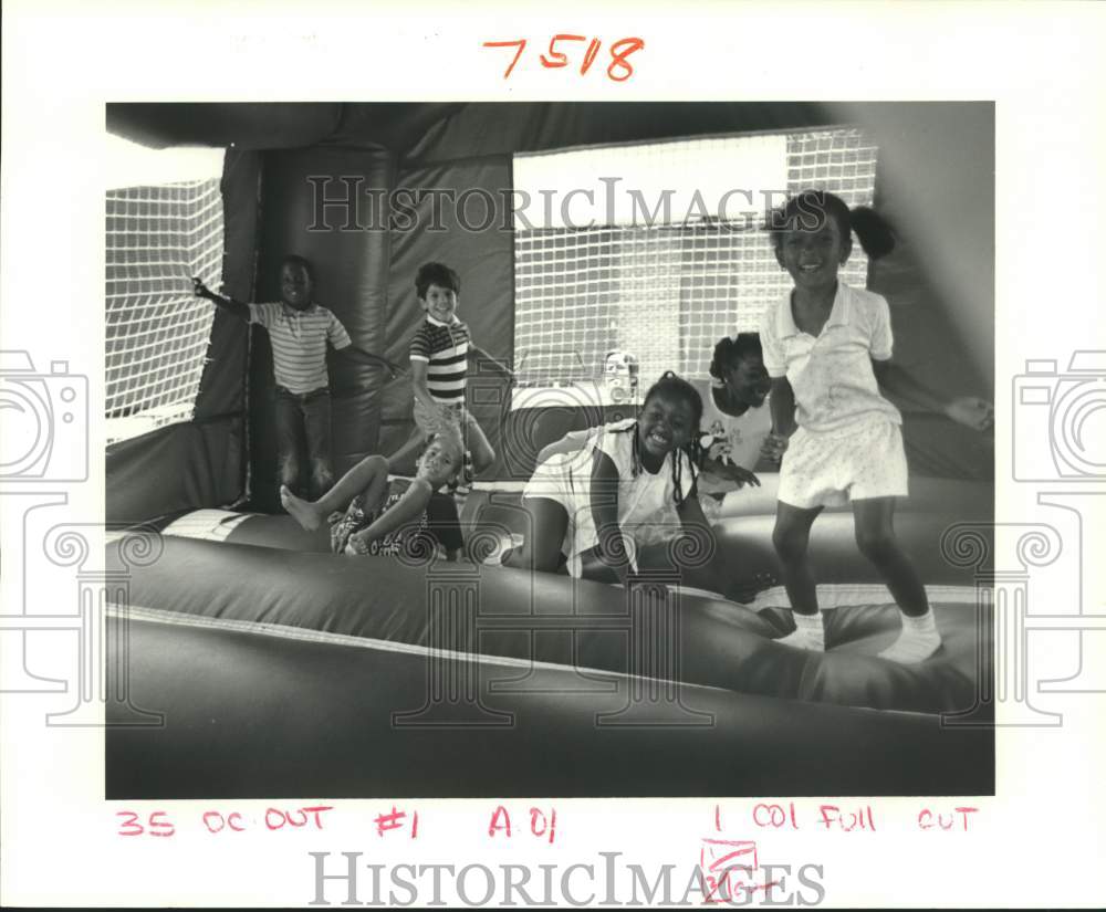 1987 Press Photo Little Woods Elementary School students at inflatable bouncer - Historic Images